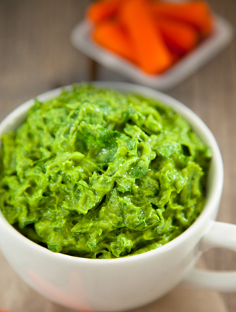 green paste in cup with carrots behind