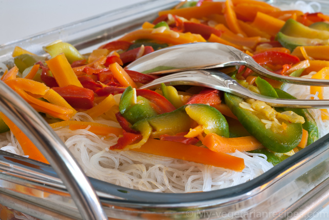 Rice noodles with vegetables in a tray with fork and spoon